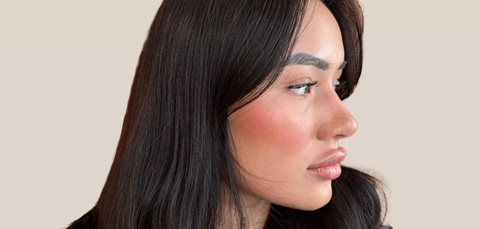 Side-profile photo of a woman with full, sculpted lips, illustrating the impact of choosing the right lip filler shape.