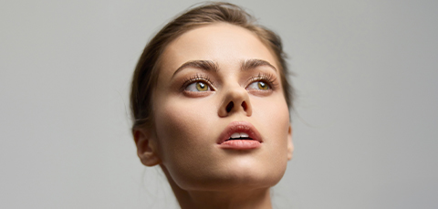 Woman looking upward with smooth facial features representing successful facelift correction results.