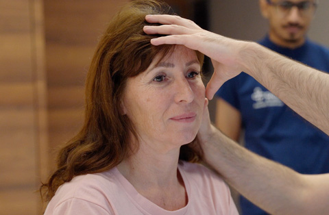 Surgeon performing pre-op exam on female patient before plastic surgery procedure