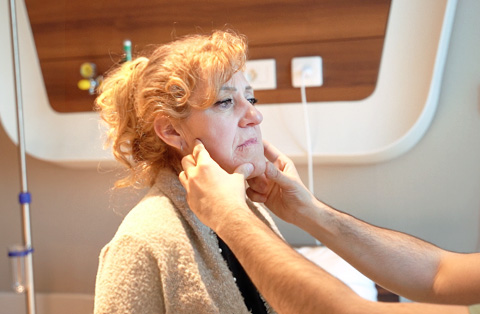 A doctor examines a patients jaw during a pre-operative exam for jaw surgery