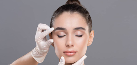 Doctor examining female face during consultation for non surgical 8 point facelift facial rejuvenation treatment