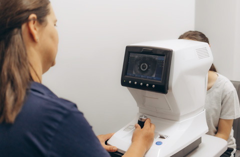 Ophthalmologist operating laser device during PRK eye exam in Turkey, preparing patient for vision correction
