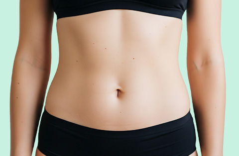 Female abdomen after tummy tuck surgery in Turkey, showing smooth, tightened skin and contoured waistline