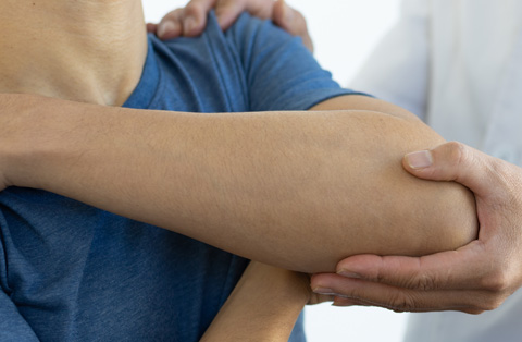 Physician supporting patients arm during upper extremity reconstruction for functional recovery in Turkey