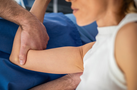 Patient undergoing nerve decompression surgery assessment for upper extremity nerve pain and mobility.